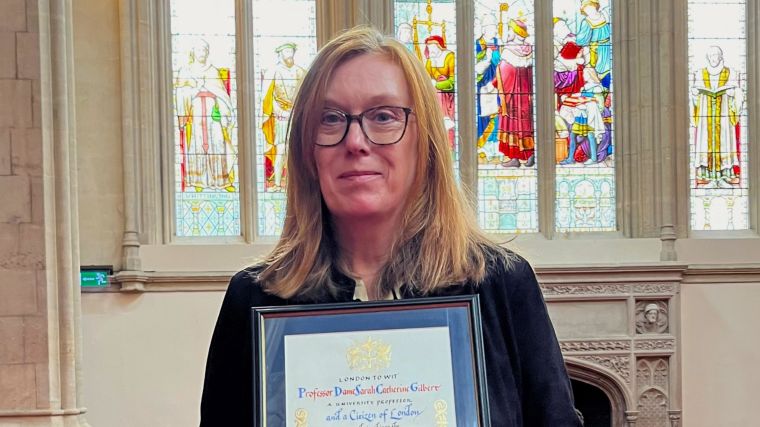 Professor Dame Sarah Gilbert holding her Freedom of the City of London certificate.